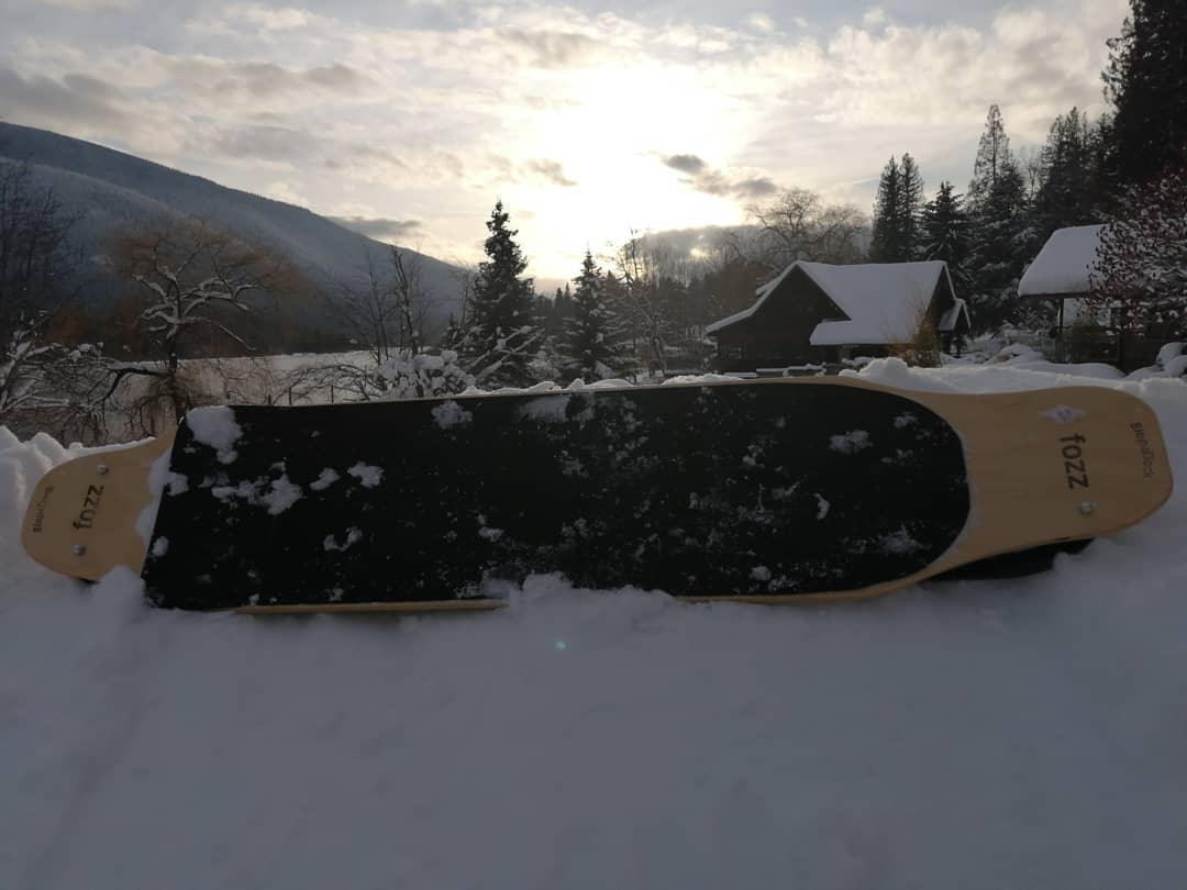 Custom Fozz Longboard with exposed maple nose and tail shown on snow
