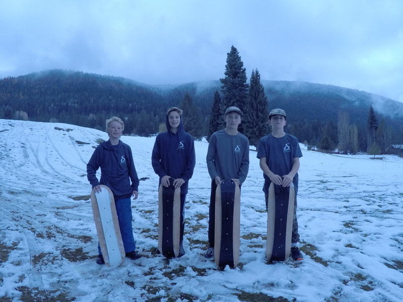 Four young SlopeDeck riders with their boards on a local hill